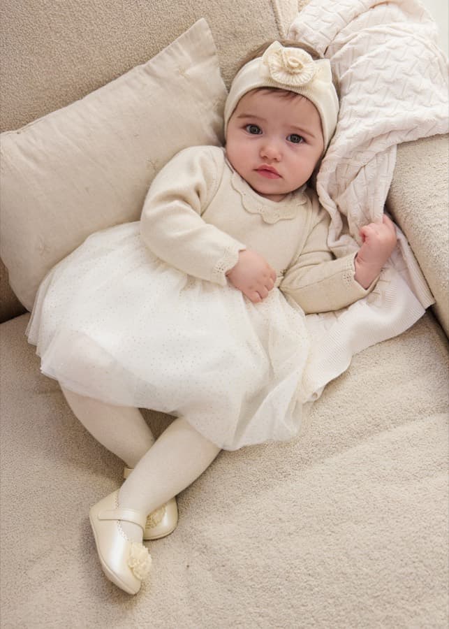 Baby girl in a cream Mayoral knitted tulle dress